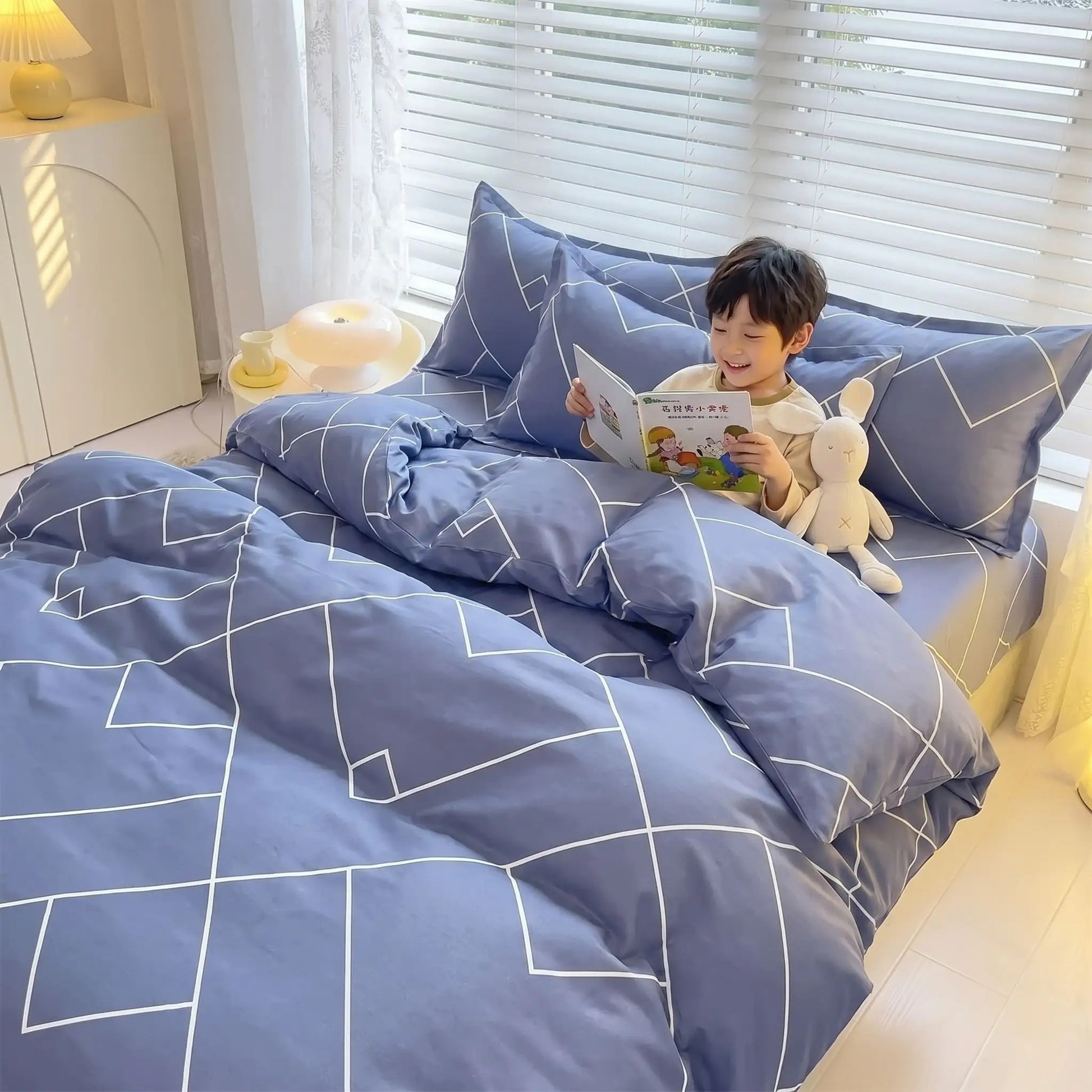 jeune garçon qui lit dans son lit avec couette 40x200 bleu